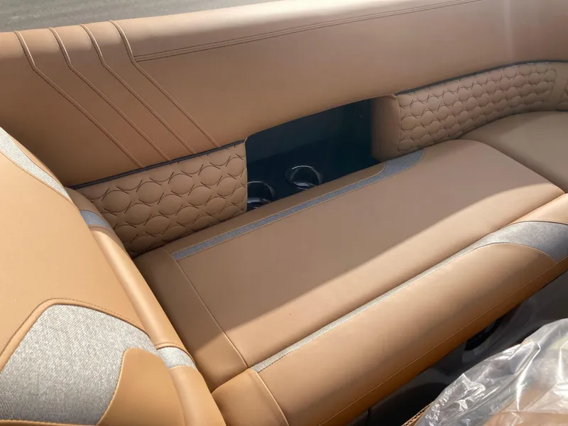 Slide: The Image of 2022 Crest Caribbean LX 230 SLS boat interior with tan leather seating and cup holders. - 8