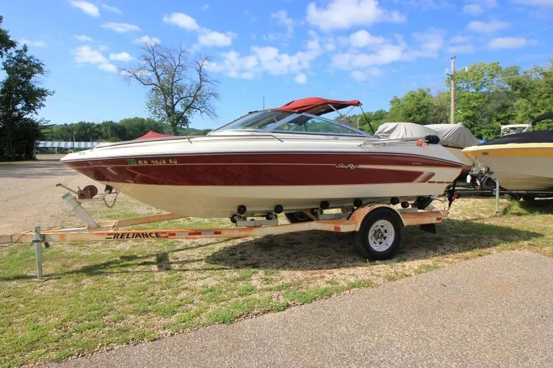 Slide: The Image of 1994 Sea Ray 180 Bow Rider boat on trailer, parked outdoors under blue sky. - 1