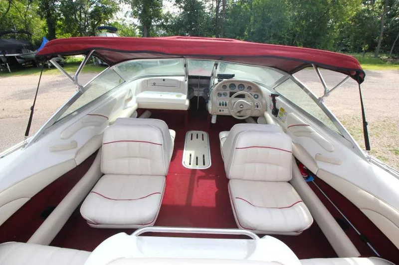 Slide: The Image of 1994 Sea Ray 180 Bow Rider interior with red canopy and white seating. - 11