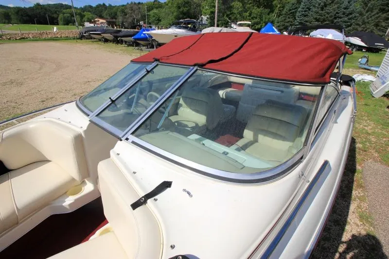 Slide: The Image of 1994 Sea Ray 180 Bow Rider with red canopy, parked outdoors. - 17