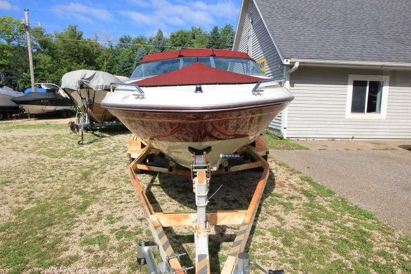 Slide: The Image of 1994 Sea Ray 180 Bow Rider on trailer, parked beside a house. - 2