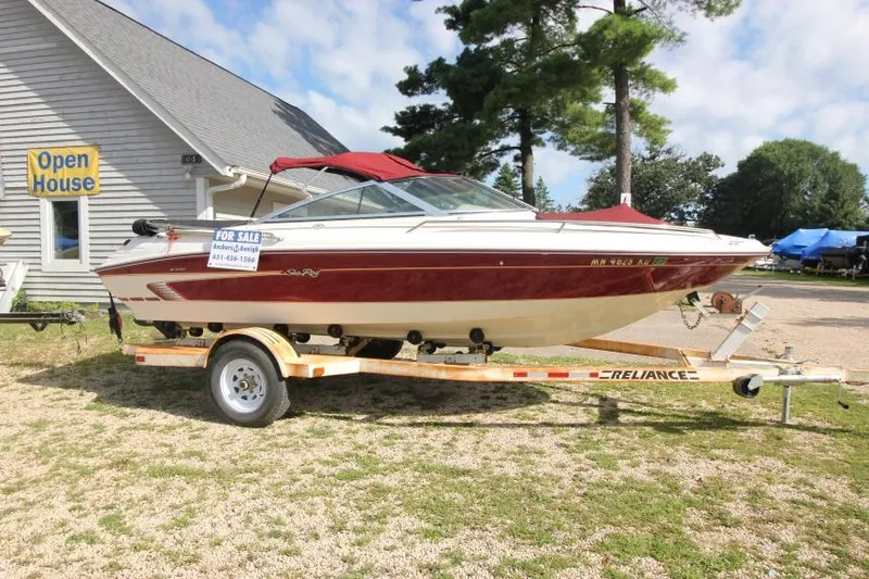 Slide: The Image of 1994 Sea Ray 180 Bow Rider boat on trailer, for sale outside a building. - 3