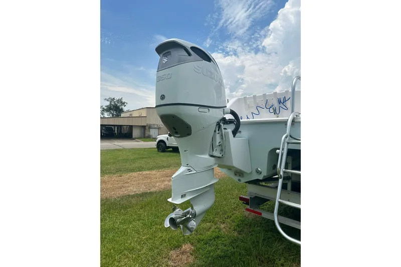 Slide: The Image of 2023 Twin Vee 340 GFX CC boat with Suzuki 350 outboard motor, parked on grass. - 10