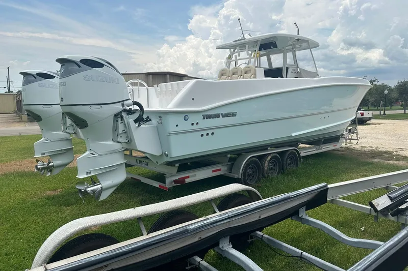 Slide: The Image of 2023 Twin Vee 340 GFX CC boat on trailer with dual Suzuki outboard engines. - 12