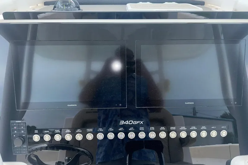 Slide: The Image of 2023 Twin Vee 340 GFX CC dashboard with dual Garmin screens and control panel. - 20