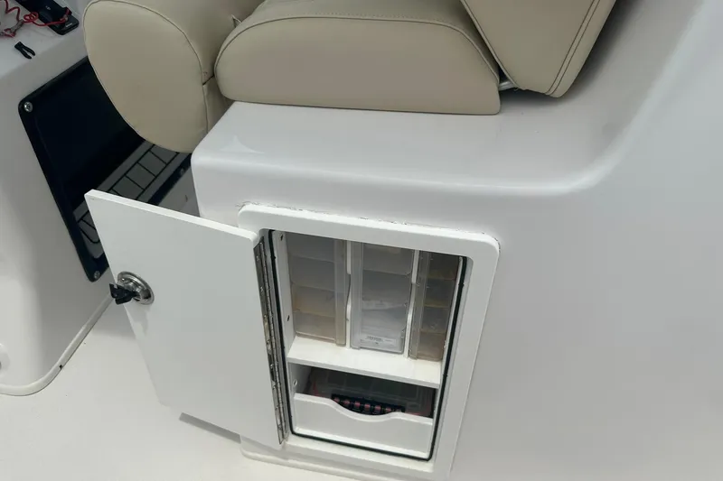 Slide: The Image of 2023 Twin Vee 340 GFX CC boat storage compartment with open door and beige seating. - 28