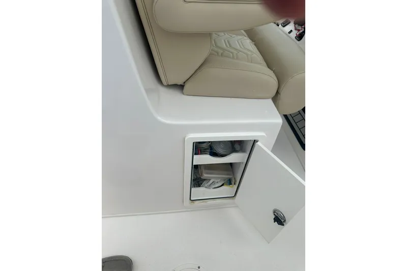 Slide: The Image of 2023 Twin Vee 340 GFX CC boat storage compartment with open door and beige seating. - 29