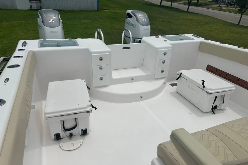 Slide: The Image of 2023 Twin Vee 340 GFX CC boat deck with Suzuki engines and storage compartments. - 35