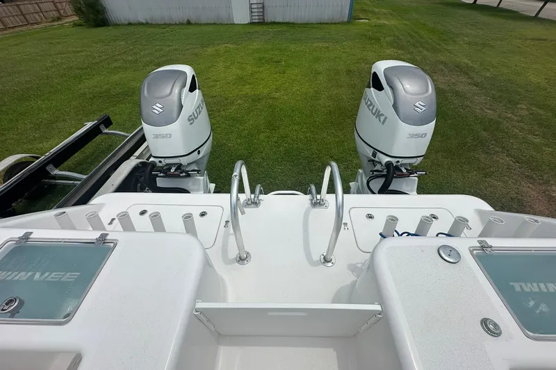 Slide: The Image of 2023 Twin Vee 340 GFX CC boat with dual Suzuki 350 engines on grassy background. - 38
