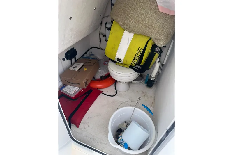 Slide: The Image of 2023 Twin Vee 340 GFX CC boat storage area with life jacket, bucket, and packages. - 45
