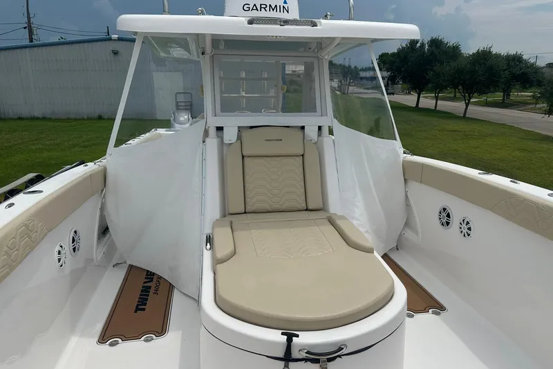 Slide: The Image of 2023 Twin Vee 340 GFX CC boat interior with beige seating and Garmin equipment. - 47