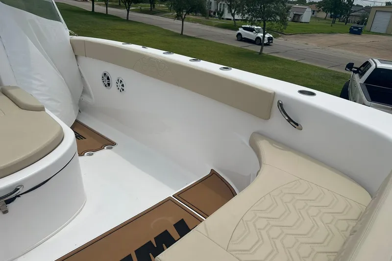 Slide: The Image of 2023 Twin Vee 340 GFX CC boat interior with beige seating and cup holders. - 49