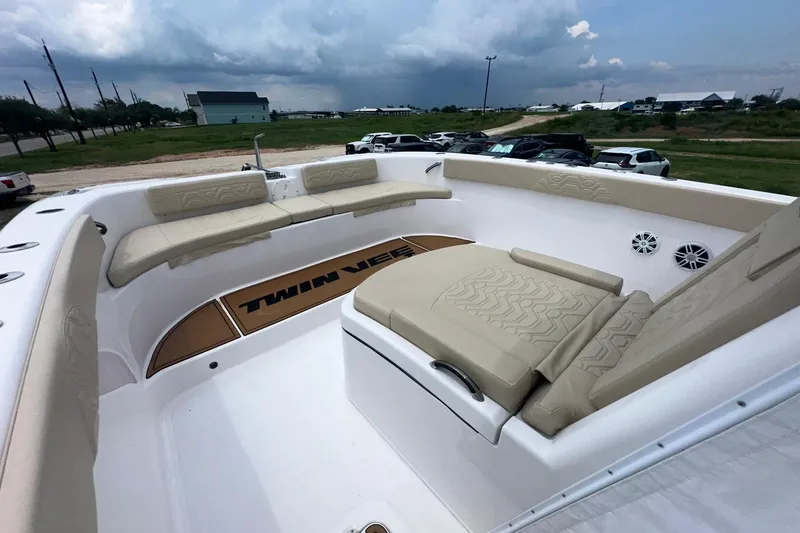 Slide: The Image of 2023 Twin Vee 340 GFX CC boat interior with beige seating and spacious deck. - 53
