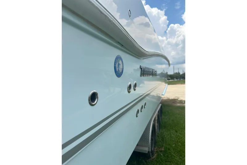 Slide: The Image of 2023 Twin Vee 340 GFX CC boat side view with logo and sleek design. - 7