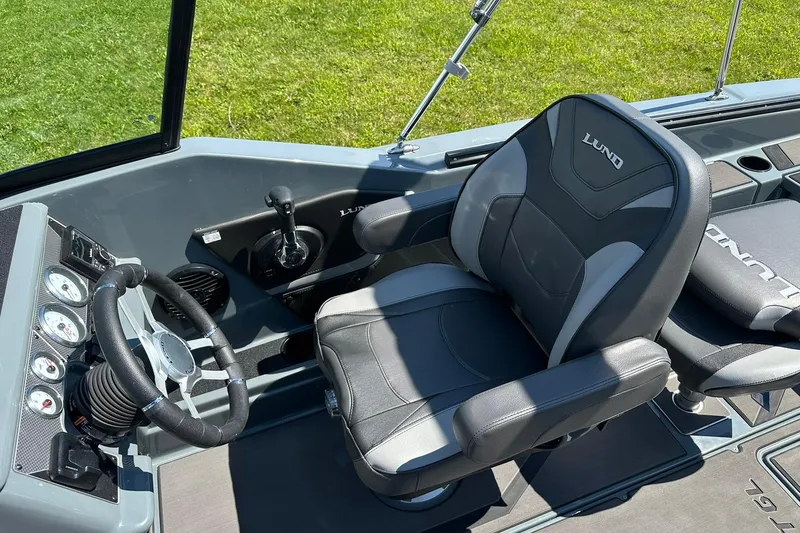 Slide: The Image of 2026 Lund 185 Impact GL boat interior with steering wheel and cushioned seats. - 17