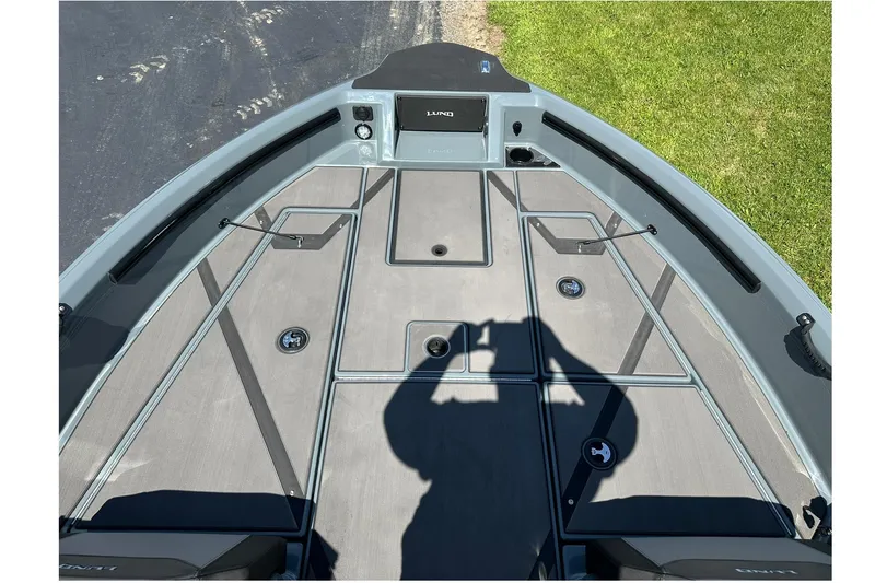 Slide: The Image of 2026 Lund 185 Impact GL boat deck with storage compartments and shadow. - 22