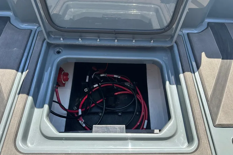 Slide: The Image of Open storage compartment in 2026 Lund 185 Impact GL boat, showing wiring and battery. - 39