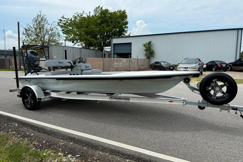 Slide: The Image of 2026 Maverick 17 HPX-S boat on trailer, parked near industrial building. - 5