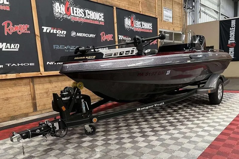 The Image of 2015 Ranger 1880 Angler boat on trailer in showroom, featuring Minn Kota motor. - 1
