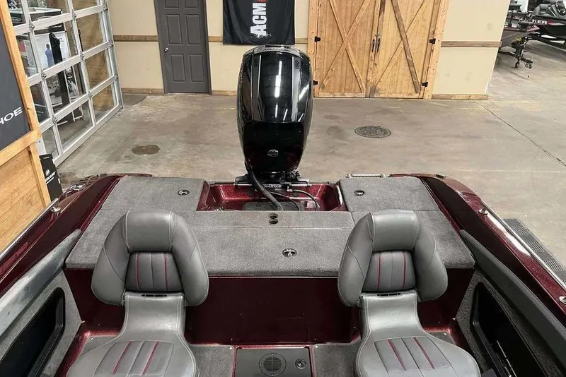 Slide: The Image of 2015 Ranger 1880 Angler boat interior with dual seats and motor in a garage setting. - 8