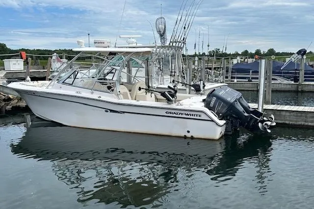 The Image of 2010 Grady-White Tournament 275 boat docked in marina, equipped with fishing rods. - 0