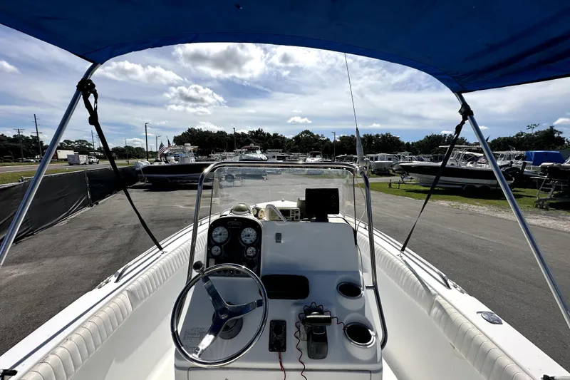 Slide: The Image of 2008 Sea Hunt Ultra 196 boat interior with steering wheel and dashboard under blue canopy. - 15