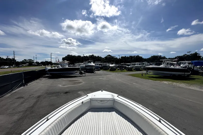 Slide: The Image of 2008 Sea Hunt Ultra 196 boat in a sunny outdoor storage area with other boats. - 20