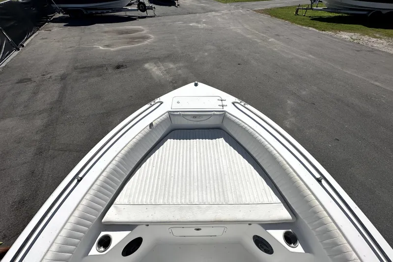 Slide: The Image of 2008 Sea Hunt Ultra 196 boat bow view, parked on asphalt, showcasing seating and storage. - 22