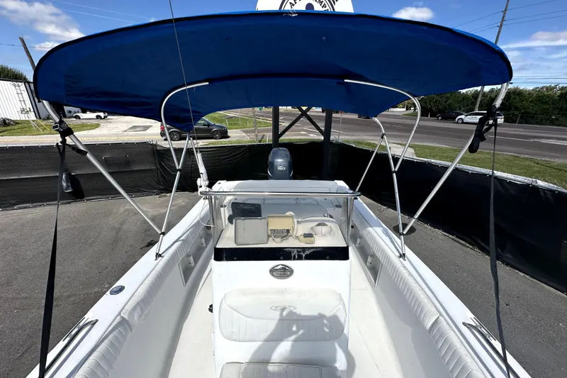 Slide: The Image of 2008 Sea Hunt Ultra 196 boat with blue canopy, parked on pavement. - 27