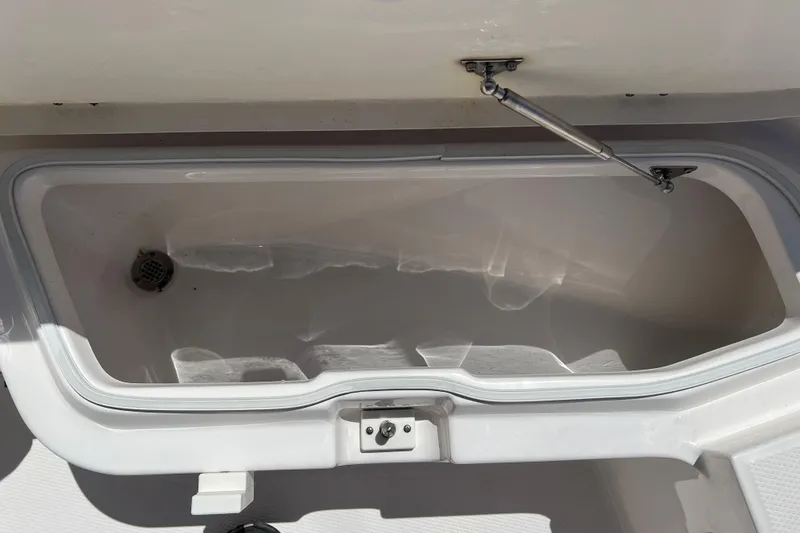 Slide: The Image of 2023 Robalo R200 Center Console storage compartment with open lid and hydraulic support. - 16