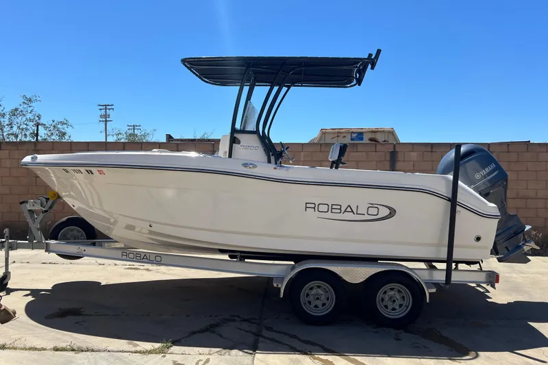 Slide: The Image of 2023 Robalo R200 Center Console boat on trailer, side view, sunny day. - 2