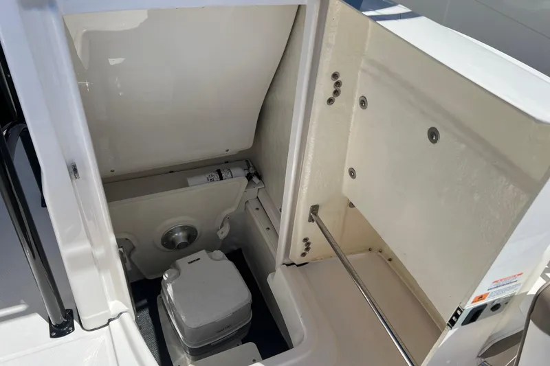 Slide: The Image of 2023 Robalo R200 Center Console boat interior with compact marine toilet. - 28