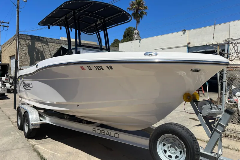 Slide: The Image of 2023 Robalo R200 Center Console boat on trailer, parked outdoors. - 34