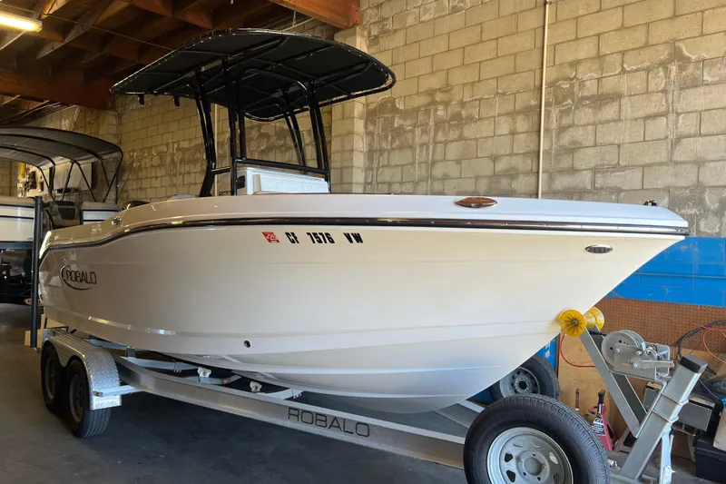Slide: The Image of 2023 Robalo R200 Center Console boat on trailer in indoor storage. - 4