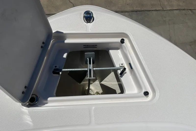 Slide: The Image of 2023 Robalo R200 Center Console anchor storage compartment, open lid, showing anchor inside. - 44