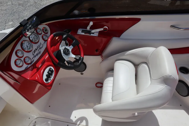 Slide: The Image of 2007 Caravelle Interceptor 232SS Bow Rider dashboard with red accents and white seating. - 10