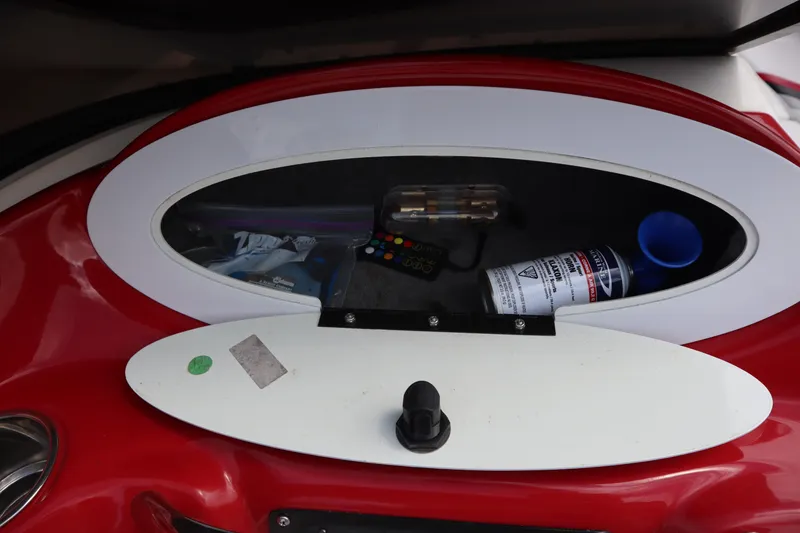 Slide: The Image of Storage compartment in a 2007 Caravelle Interceptor 232SS Bow Rider boat, containing various items. - 15