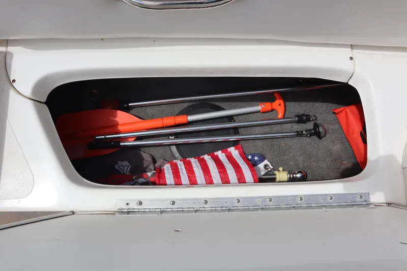 Slide: The Image of Storage compartment of 2007 Caravelle Interceptor 232SS Bow Rider with boating gear and American flag. - 25