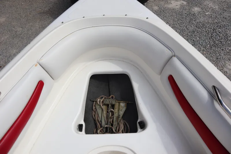 Slide: The Image of 2007 Caravelle Interceptor 232SS Bow Rider anchor storage with red and white seating. - 6