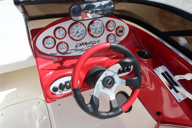 Slide: The Image of 2007 Caravelle Interceptor 232SS Bow Rider dashboard with red accents and steering wheel. - 9