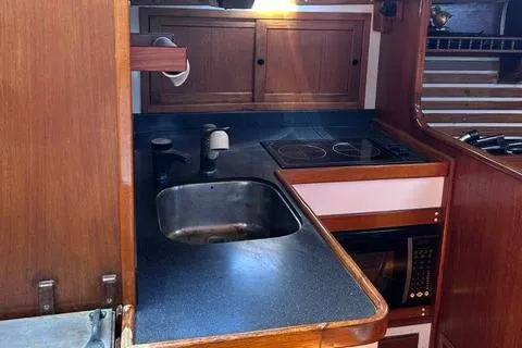 Slide: The Image of 1972 Cheoy Lee Offshore 47 Yawl galley with sink, stove, and wooden cabinetry. - 12