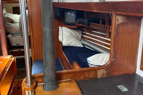 Slide: The Image of Interior of 1972 Cheoy Lee Offshore 47 Yawl, featuring cozy cabin with seating and TV. - 14