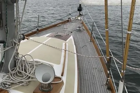 Slide: The Image of 1972 Cheoy Lee Offshore 47 Yawl sailboat deck with ropes and wooden details on the water. - 19