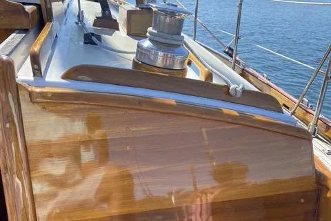 Slide: The Image of 1972 Cheoy Lee Offshore 47 Yawl with polished wood deck and winch, docked by the water. - 27