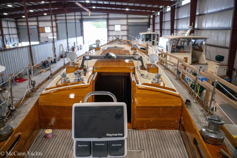 Slide: The Image of 1972 Cheoy Lee Offshore 47 Yawl in a boatyard, showcasing polished wood and navigation equipment. - 7