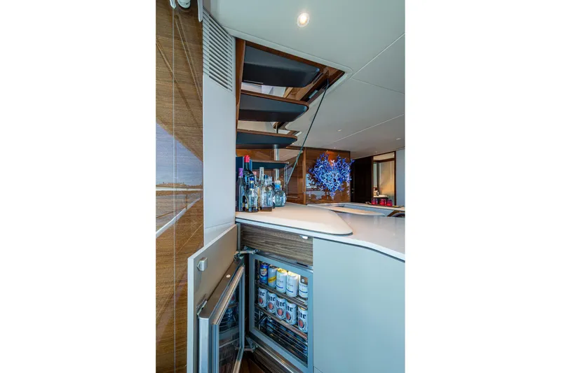 Slide: The Image of Luxurious 2022 Princess X95 yacht interior with bar, open fridge, and modern decor. - 21
