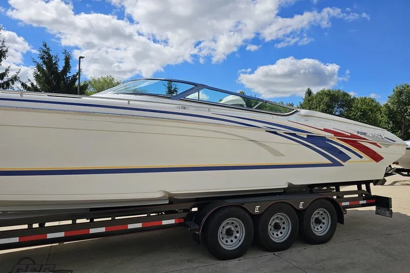 Slide: The Image of 2012 Formula 382 FASTech boat on trailer, vibrant graphics, under blue sky. - 14