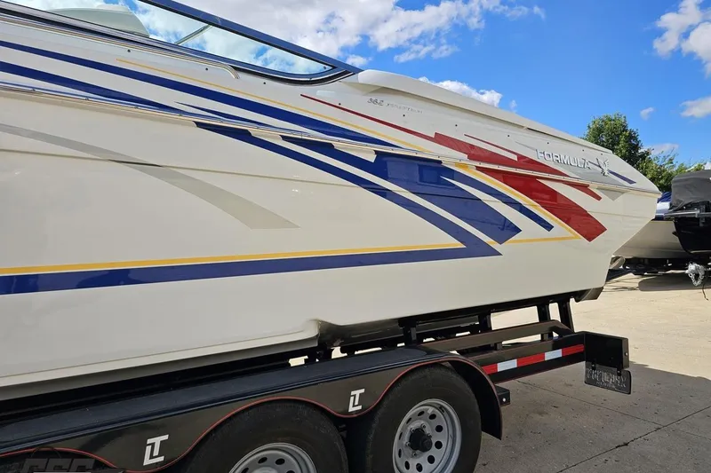 Slide: The Image of 2012 Formula 382 FASTech boat with colorful graphics on a trailer under a blue sky. - 15