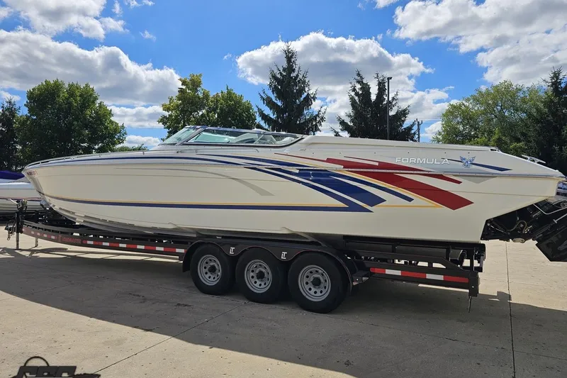 Slide: The Image of 2012 Formula 382 FASTech boat on trailer, vibrant graphics, parked outdoors under blue sky. - 18