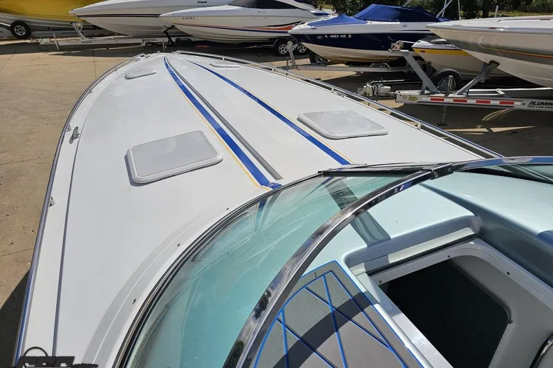 Slide: The Image of 2012 Formula 382 FASTech boat with sleek design and blue accents, docked among other boats. - 52